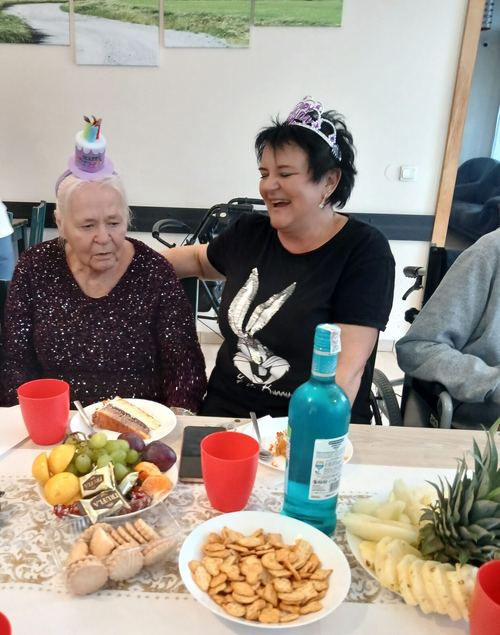 Urodzinowy stół z owocami, ciastem i przekąskami, jubilatka w papierowej czapeczce w CuratioW w Rajczy