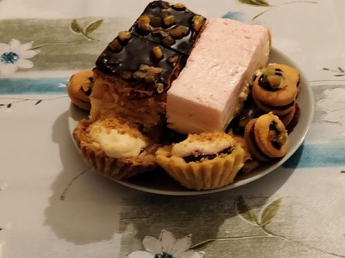 Talerz wielkanocnych ciast — mazurek, babeczki z owocami i pianka — w Domu Aktywnego Seniora CuratioW