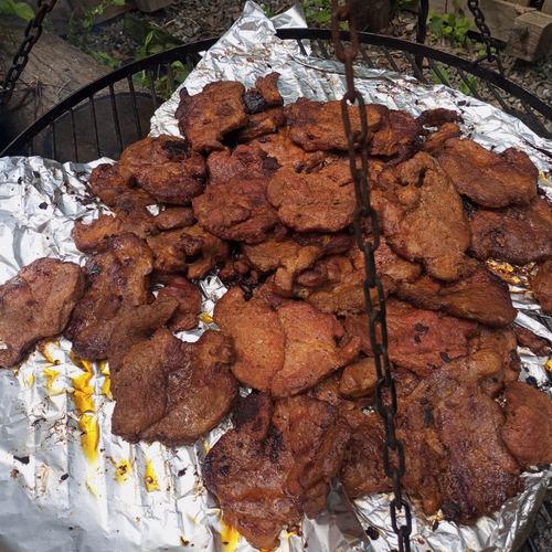 Mięso pieczone na grillu nad ogniskiem podczas pikniku w Domu Aktywnego Seniora CuratioW