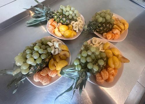 Misy z owocami — winogrona, ananas, mandarynki, brzoskwinie, banan — przygotowane jako deser w Domu Aktywnego Seniora CuratioW