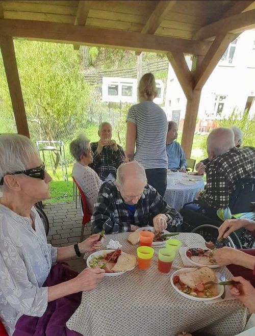 Piknik mieszkańców Domu Aktywnego Seniora CuratioW z opiekunami w altanie ogrodowej w Rajczy